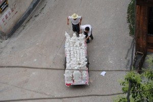 Workers can be hired for 40 cents to move pottery pieces by hand on carts in Jingdezhen.