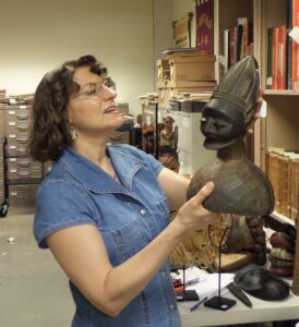 Dr. Billie Follensbee holds an African bust.