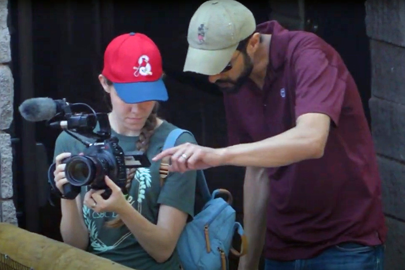 Man working with woman on film camera