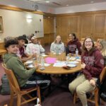 Access and Success students sit around a table at Bears Lead monthly meeting.