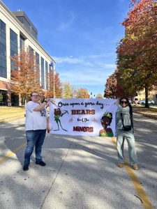 Students holding banner "Once upon a game day, bears beat the miners"