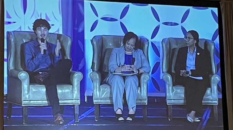 Three people speaking on a panel.