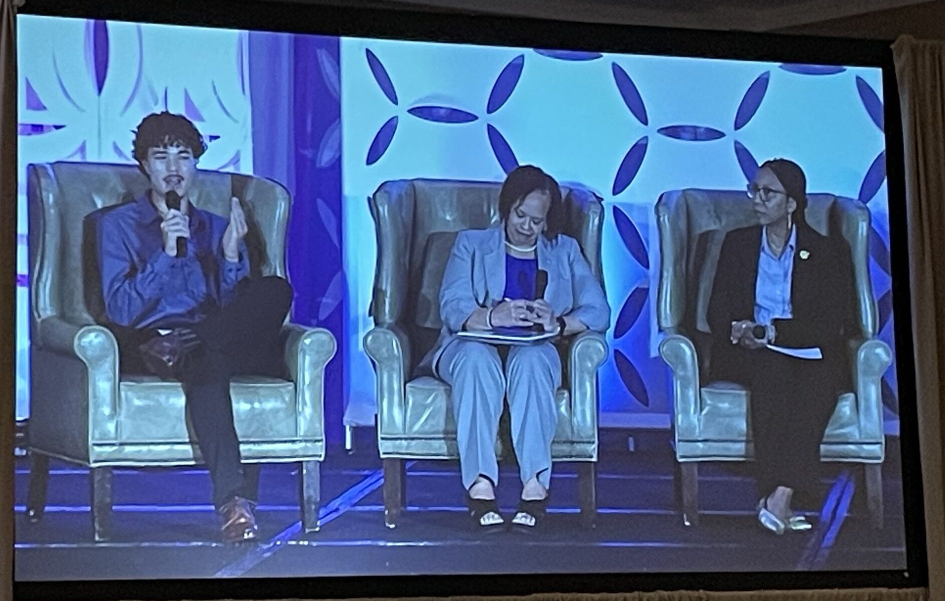 Three people speaking on a panel.