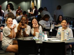 Four students sitting at a table smiling. 