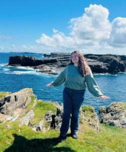 Student standing in front of the ocean.