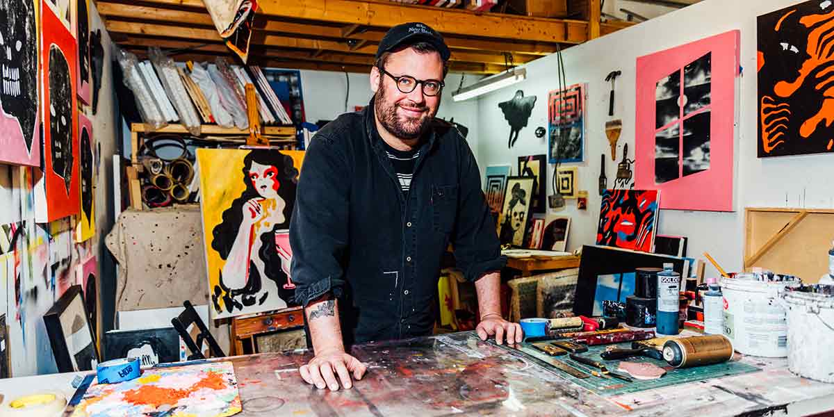 Daniel Zender in art studio with a collection of his work.
