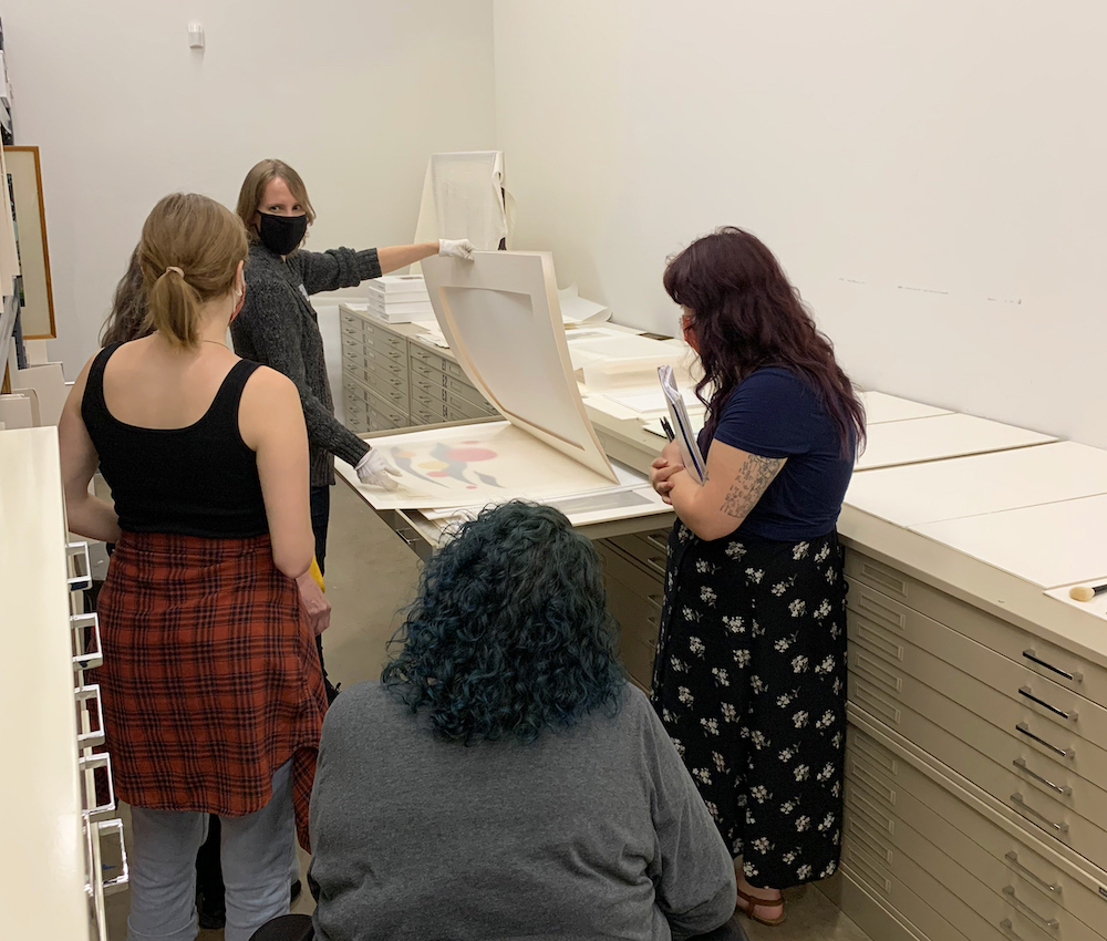 A group of students studying some of artworks in Springfield Art Museum's vault