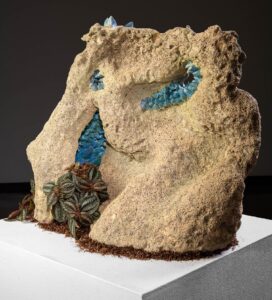 A large ceramic piece with blue crystals and foliage