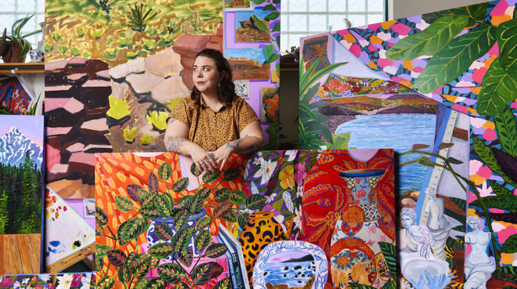 Anna Valdez stands surrounded by large, colorful paintings