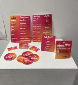 Hot pink and orange promotional materials arranged on a table
