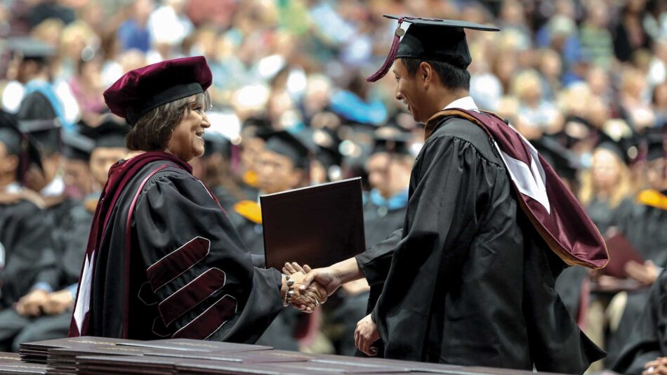 Graduate student receiving diploma at commencement