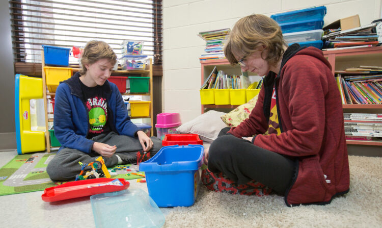 two students play with toys in Alex's class