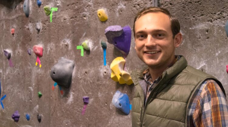 Dalton Breeding in front of climbing wall