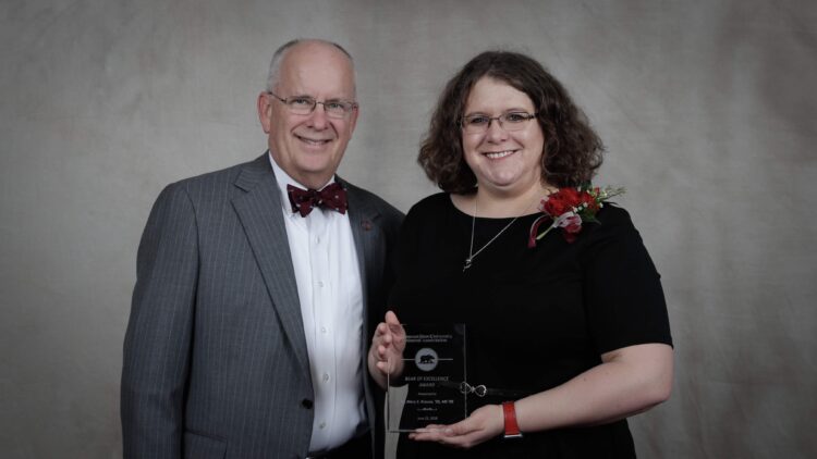 Dr. Krause holding award with President Smart
