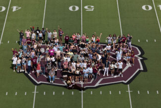 2023 graduates gather for a class photo on the Bear head at Plaster Stadium during Grad Bash 2023.