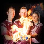 The MSU Handball team holds fiery handballs in their gloved hands.