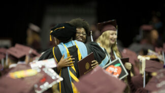 A Missouri State graduate hugs a faculty member following commencement.