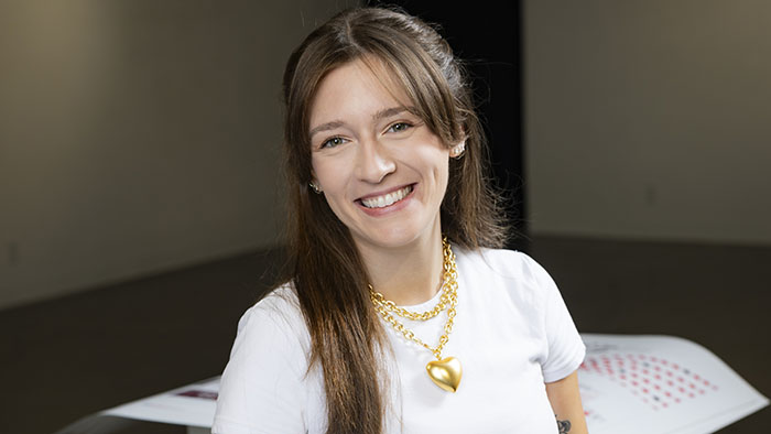 Headshot of Jadie Arnett smiling among some of her design work