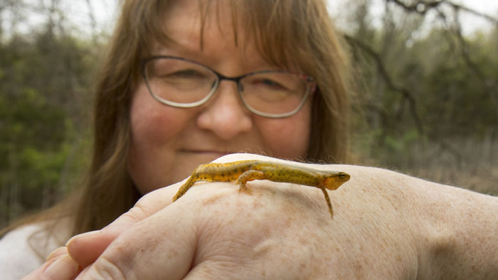 Dr. Mathis with a salamander on her hand.