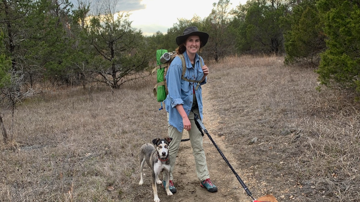 Parker Campbell hikes on trail with her dog.