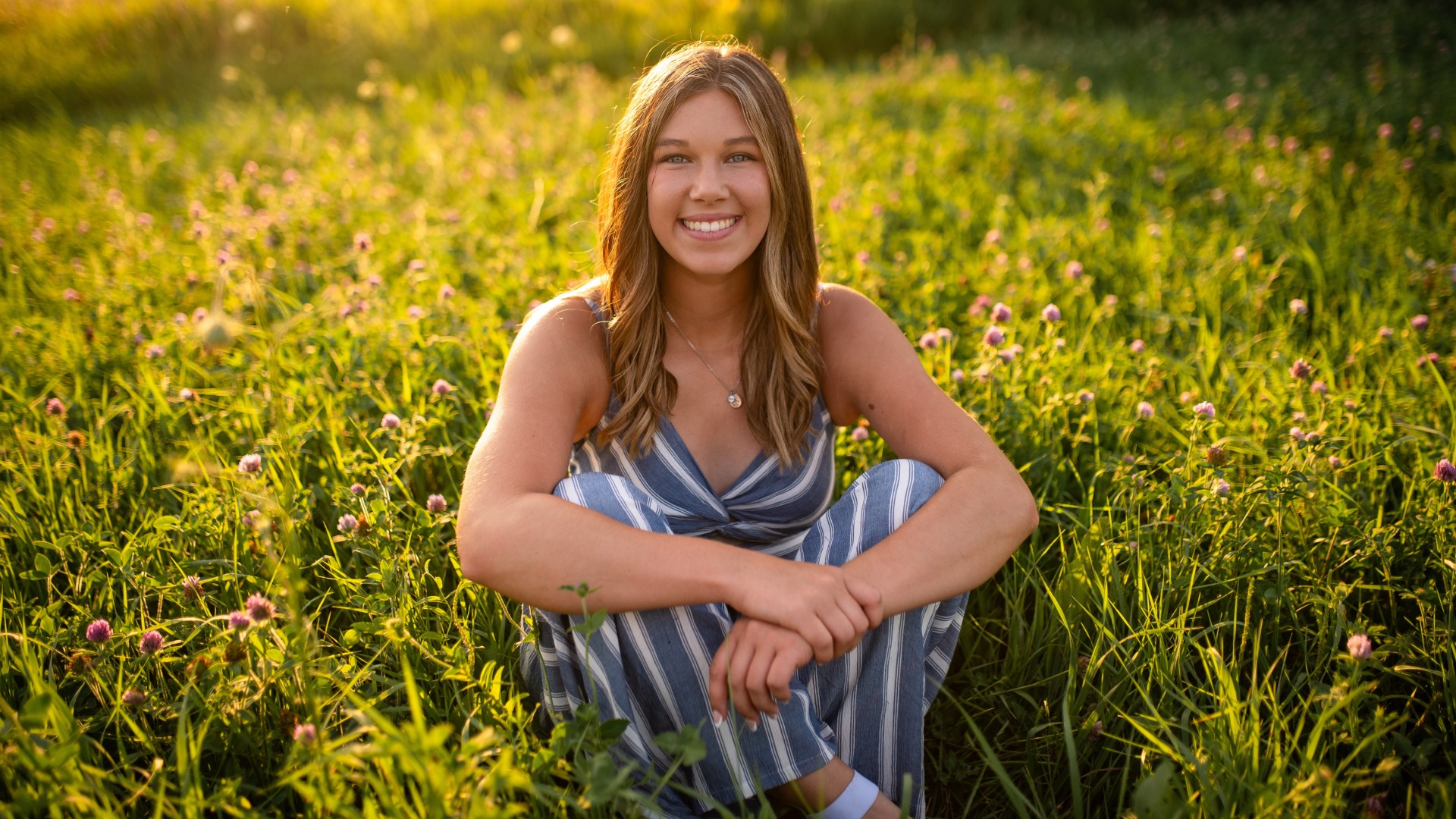 Jordan Porsch sits in the middle of a field of flowers.