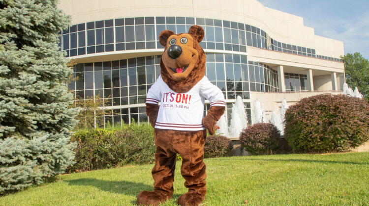 Boomer wearing "It's On!" t-shirt in front of Hammons Hall for the Performing Arts.