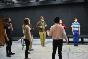 Theatre students gathered in a circle rehearsing