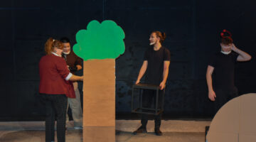 Theatre students work on staging and a tree prop