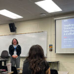 A young woman presents her research, accompanied by a presentation slideshow