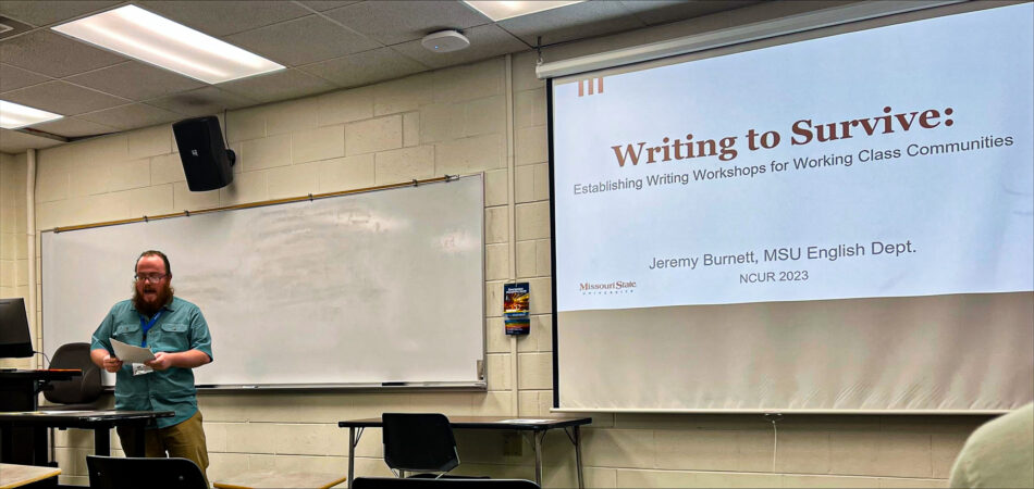 A young man presents his research, accompanied by a presentation slideshow