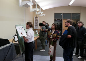 Dr. Follensbee motions to the painting and restoration and talks through Elliot-Lee's process to showcase visitors.