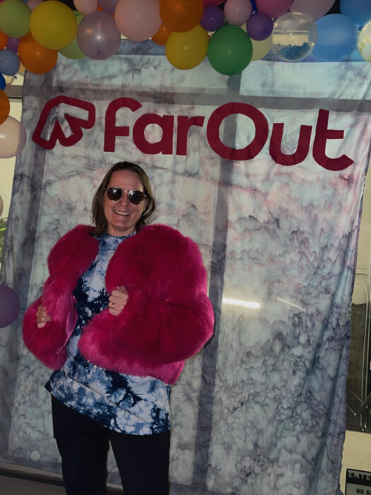 Alice poses in front of FarOut backdrop at launch party.