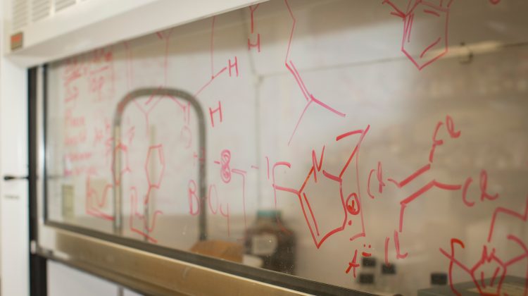Chemistry symbols written on a clear board