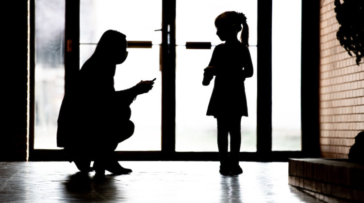 Silhouette of Dr. Boyle working with a child to develop treatment options for children with autism spectrum disorders.