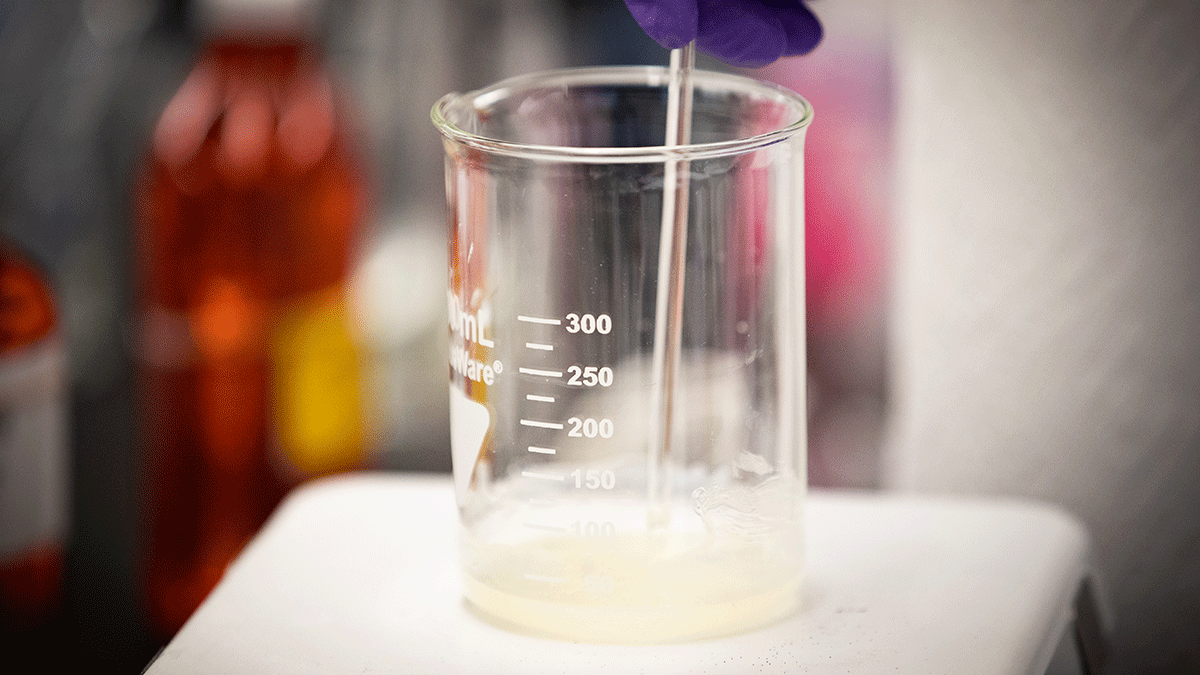 lab student stirs solution in beaker
