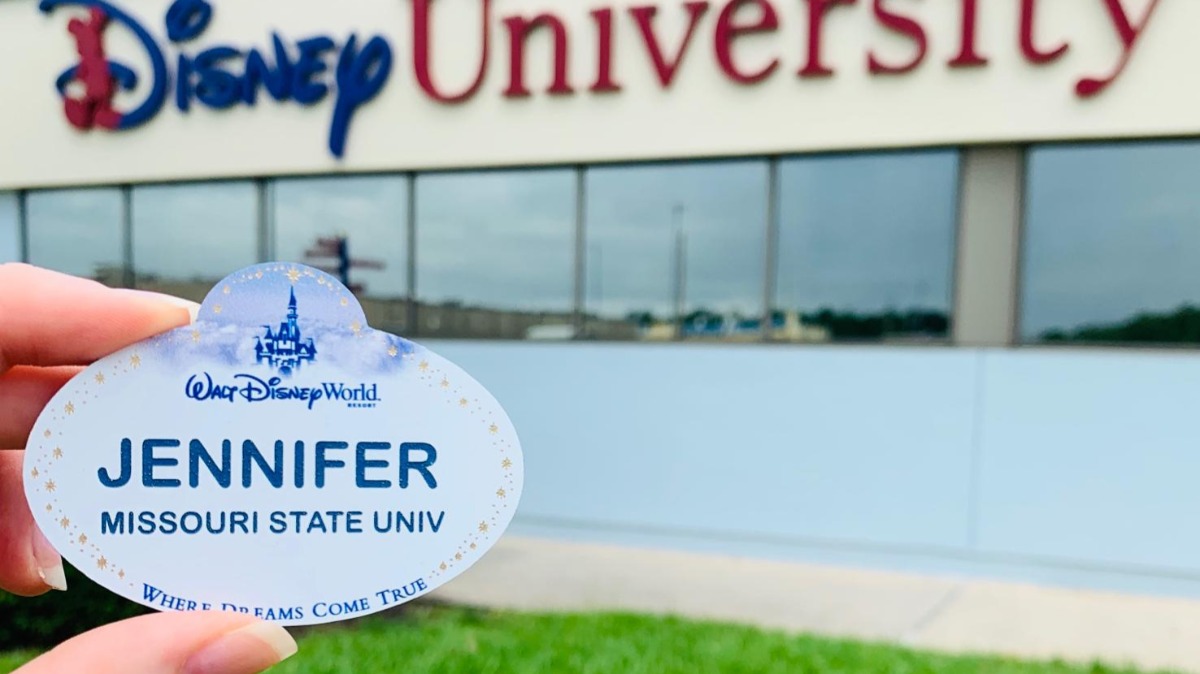 Jennifer Johnson holds up her Disney name tag in front of Disney University facility.