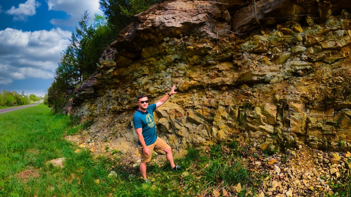 Instructor Damon Bassett poses in front of a rock wall.