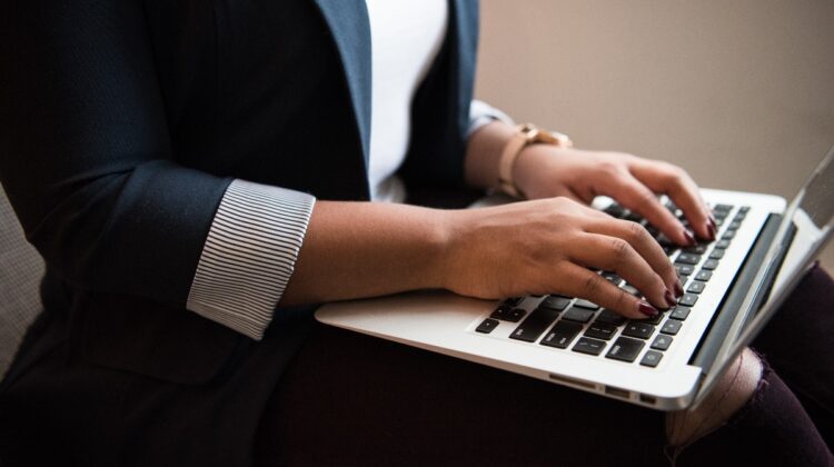 A young woman wearing a blazer types on the keyboard of her laptop. Photo by Christina Morillo from Pexels.