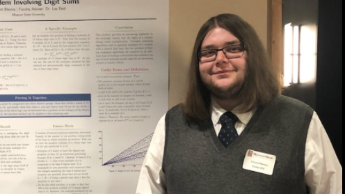 Vincent Blevins with research poster at mathematics conference.