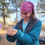 Taylor Hiers holding a Mountain Chickadee during a bird banding demonstration at the conference.