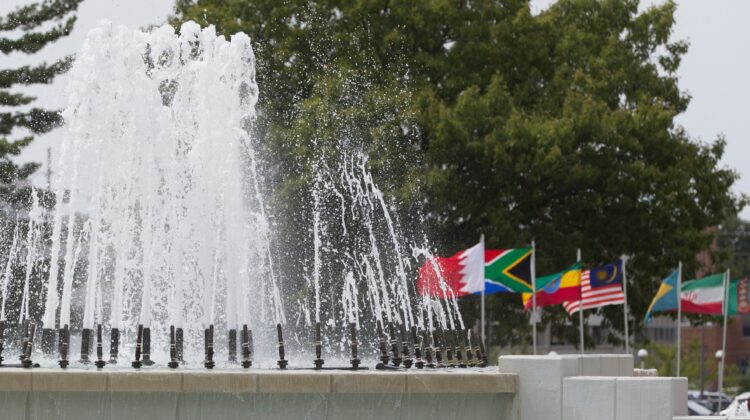 The MSU campus fountain with flags of various countries surrounding it.