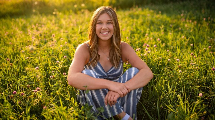 Jordan Porsch sits in the middle of a field of flowers.