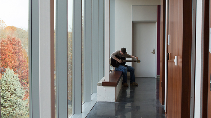 Student playing guitar in Ellis Hall