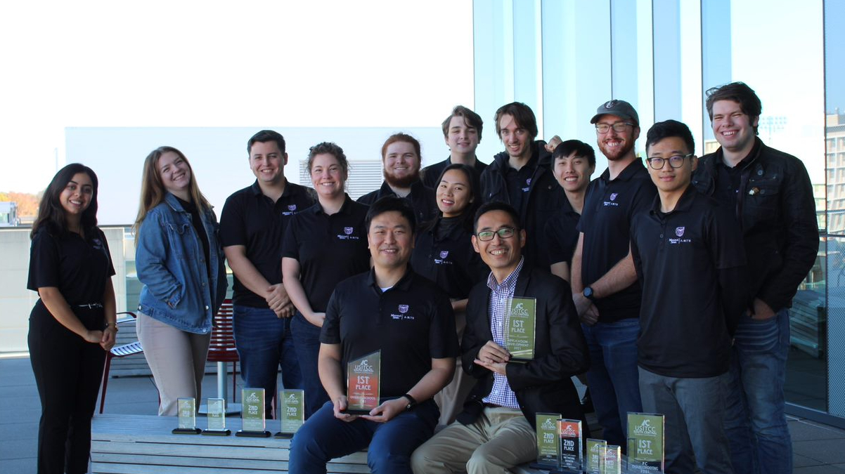 Group photo of A-BITS team with trophies.