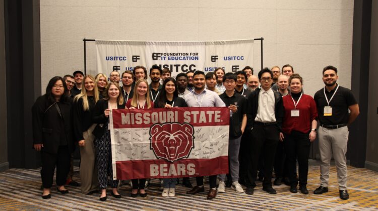 A-BITS students with Missouri State Bears flag at conference.