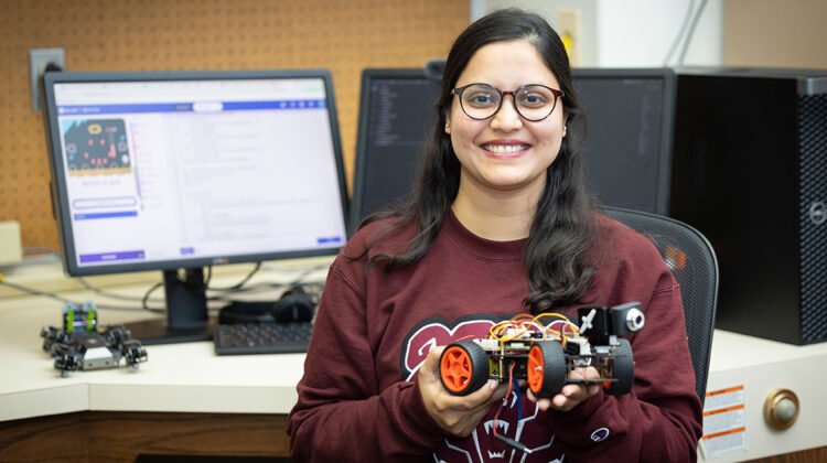 Jeniya Sultana holds a robotic gadget in a computer lab.