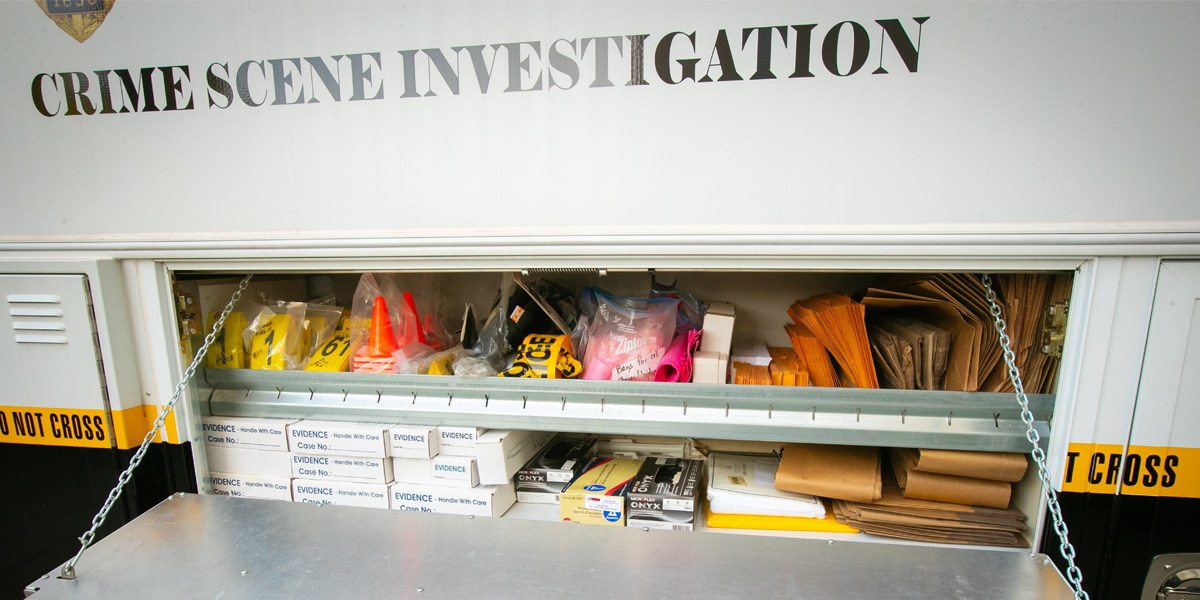 The side door to a police vehicle reveals tagging, marking, and forensic tools for crime scene investigation.