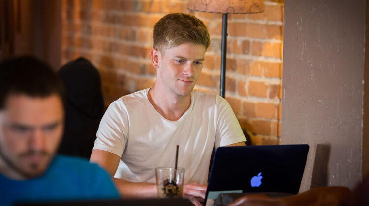 Student works on class online at a coffee shop.