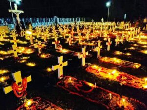 A photo of a cemetery decorated with flowers, lights and candles in celebration of All Souls' Day
