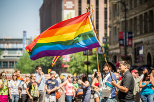 Marchers in the 2013 Twin Cities Pride parade carry rainbow flags as spectators watch along Hennepin Avenue in Minneapolis, Minnesota.